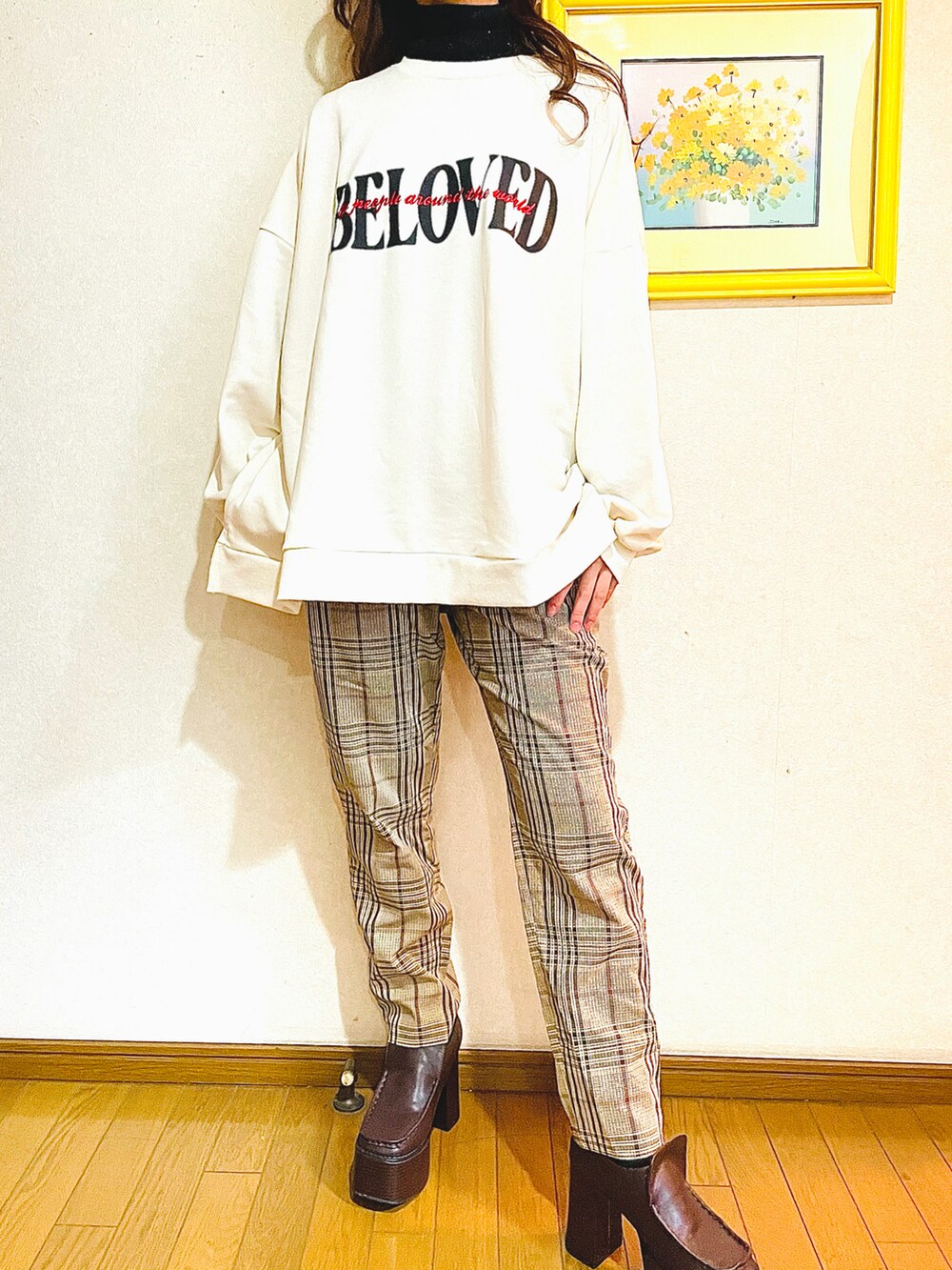 ホワイト系のスウェット、ブラウン系のスラックス、ブラウン系のローファーを着用したレディースの冬コーディネートの2枚目の写真