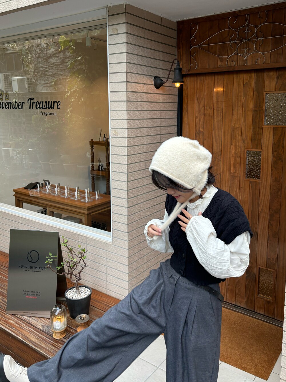 ブラック系のタンクトップ、ホワイト系のシャツ/ブラウス、グレー系のスラックスを着用したレディースの秋コーディネートの3枚目の写真