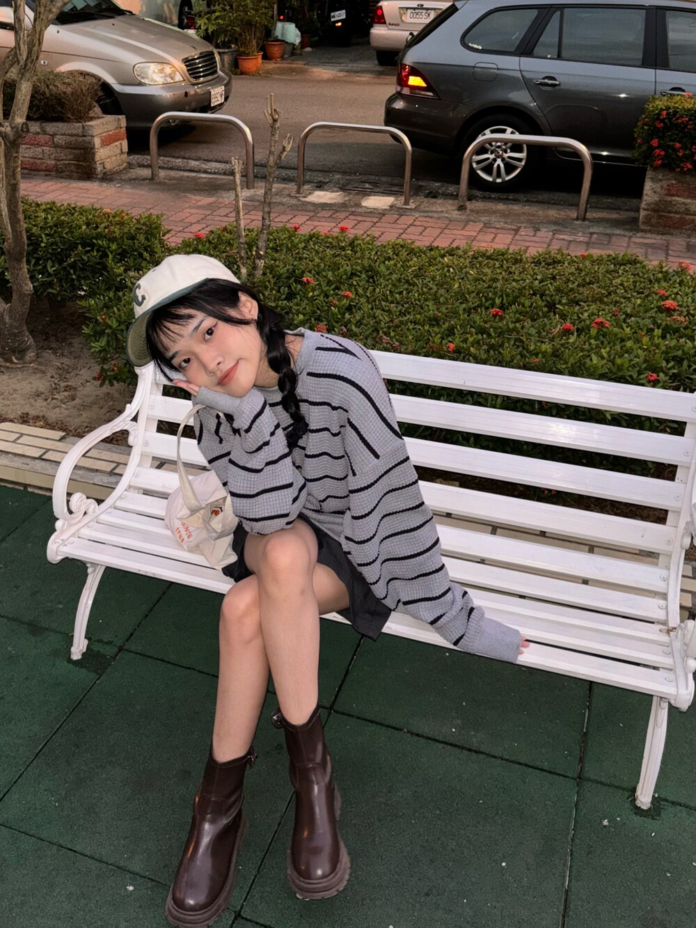 グレー系のニット/セーター、ホワイト系のショルダーバッグ、ブラウン系のブーツを着用したレディースの秋コーディネートの2枚目の写真