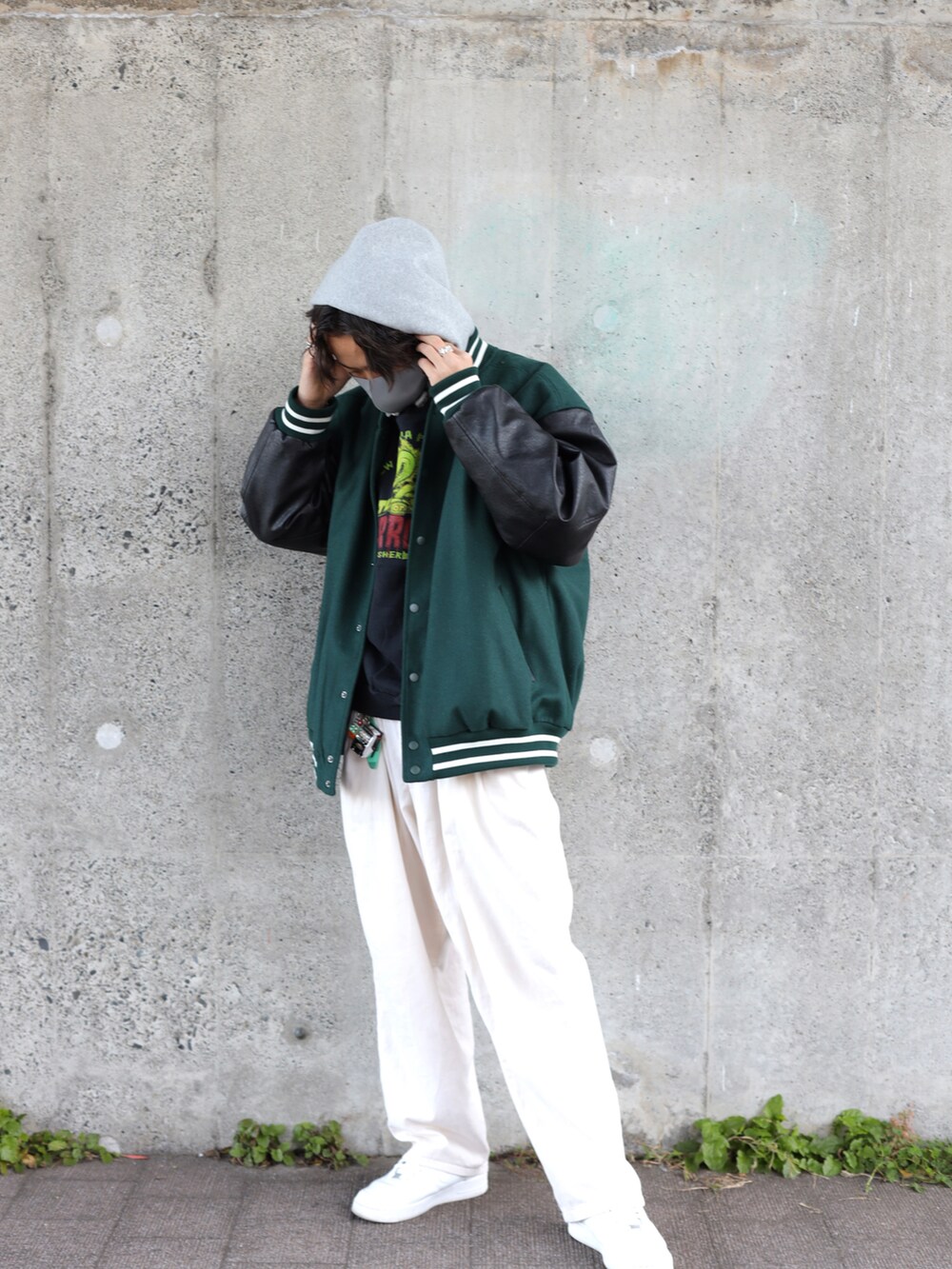 ホワイト系のスニーカー、グリーン系のスタジャン、グレー系のパーカーを着用したメンズの冬コーディネートの2枚目の写真