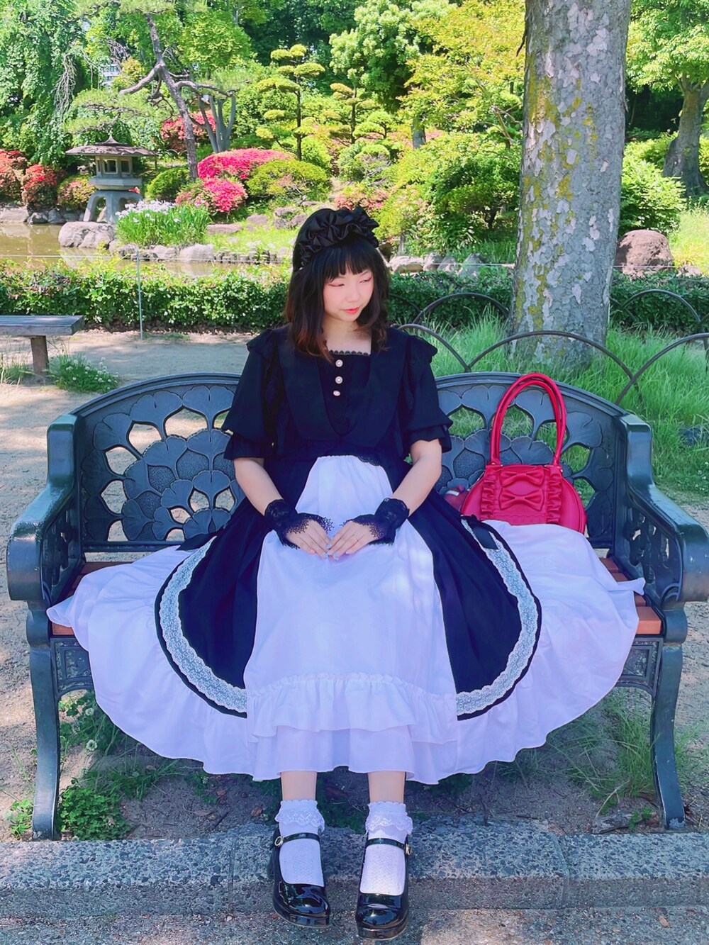 ブラック系のパンプス、ブラック系のシャツ/ブラウス、ブラック系のスカートを着用したレディースの夏コーディネートの2枚目の写真