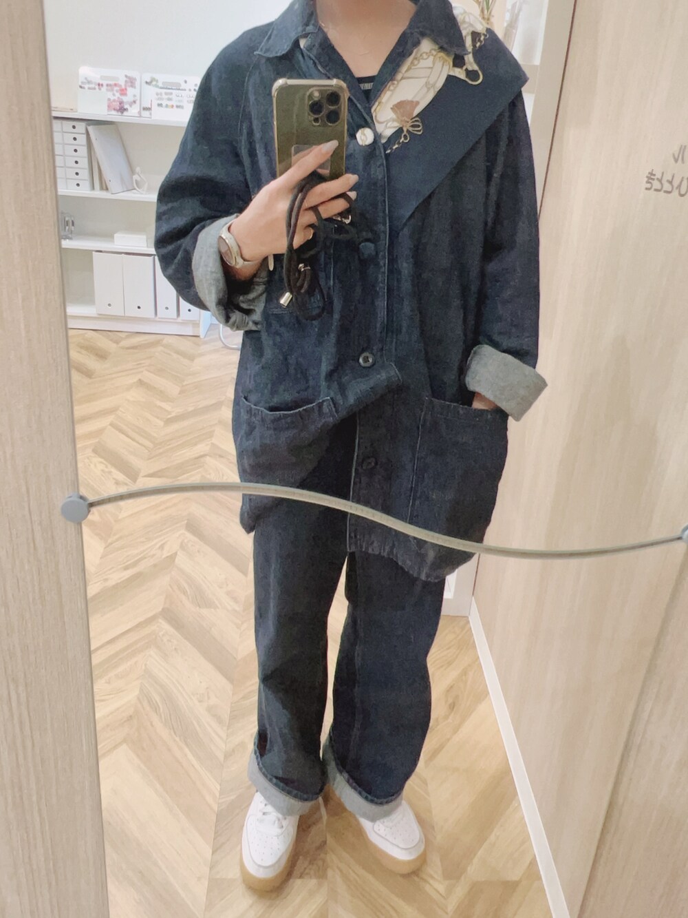 ブルー系のデニムパンツ、ブルー系のデニムジャケット、ホワイト系のスニーカーを着用したレディースの秋コーディネートの2枚目の写真