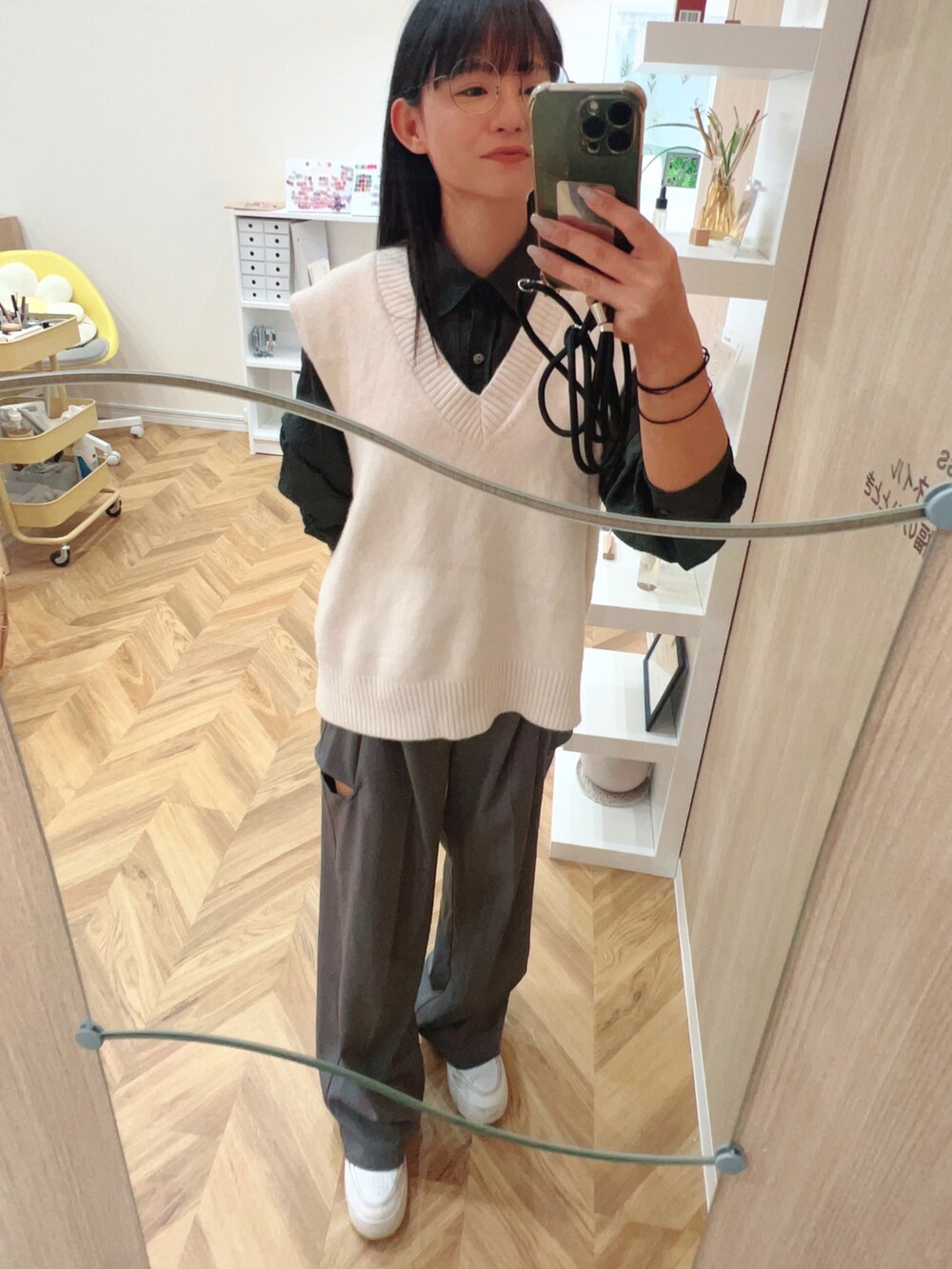 グレー系のシャツ/ブラウス、グレー系のスラックス、ホワイト系のスニーカーを着用したレディースの秋コーディネートの2枚目の写真