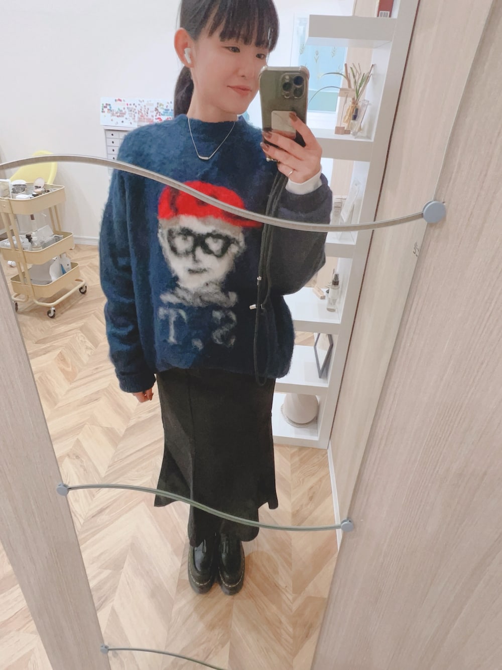 ブルー系のニット/セーター、ブラック系のスカート、ブラック系のローファーを着用したレディースの秋コーディネートの2枚目の写真