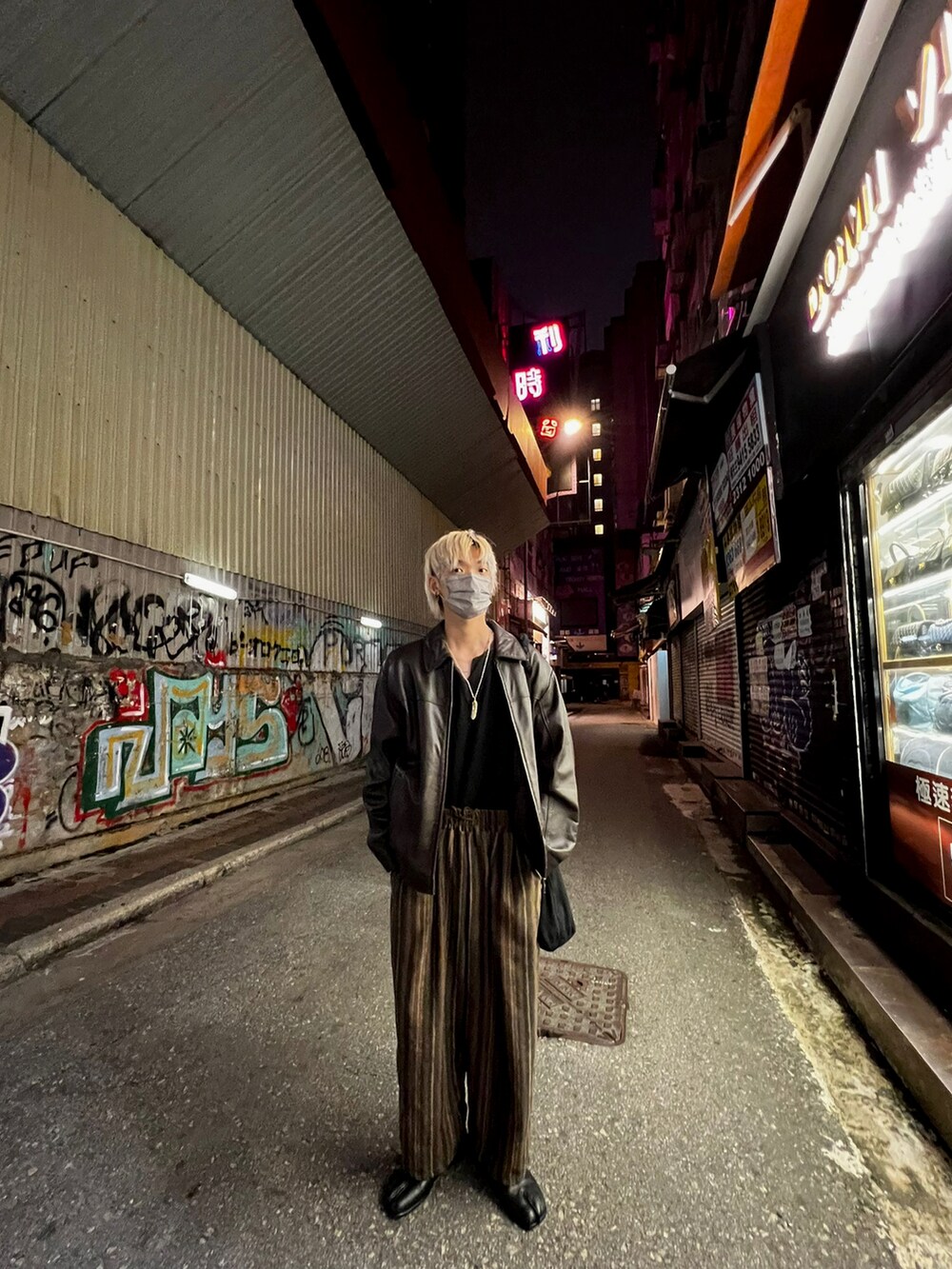 ブラック系のTシャツ/カットソー、ブラウン系のチノパンツ、ブラック系のローファーを着用したメンズの秋コーディネートの2枚目の写真