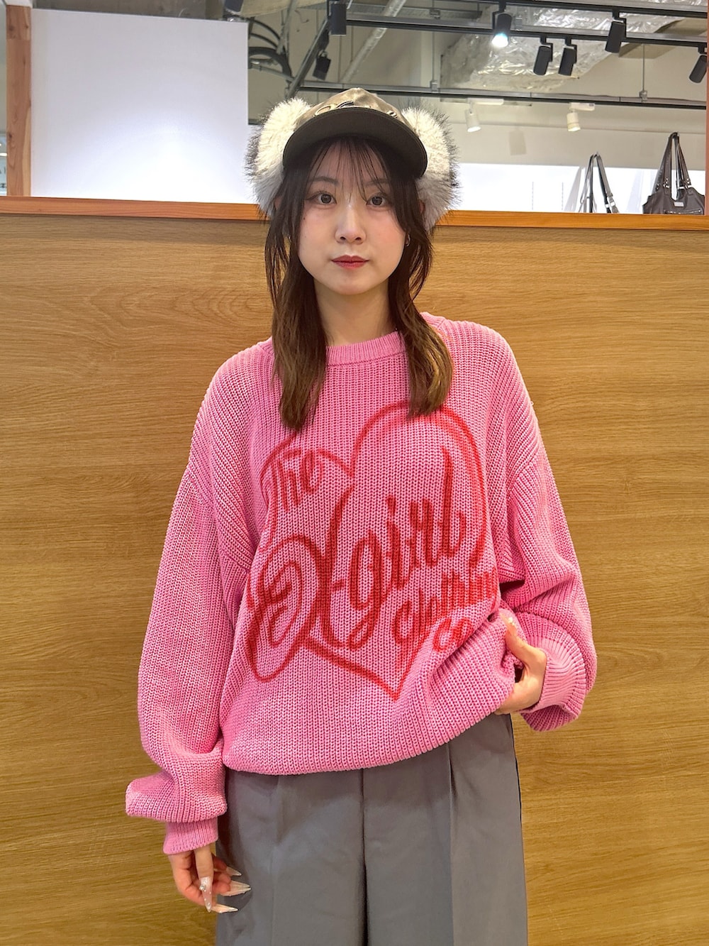 ピンク系のニット/セーター、グレー系のスラックス、ブラック系のキャップを着用したレディースの秋コーディネートの4枚目の写真