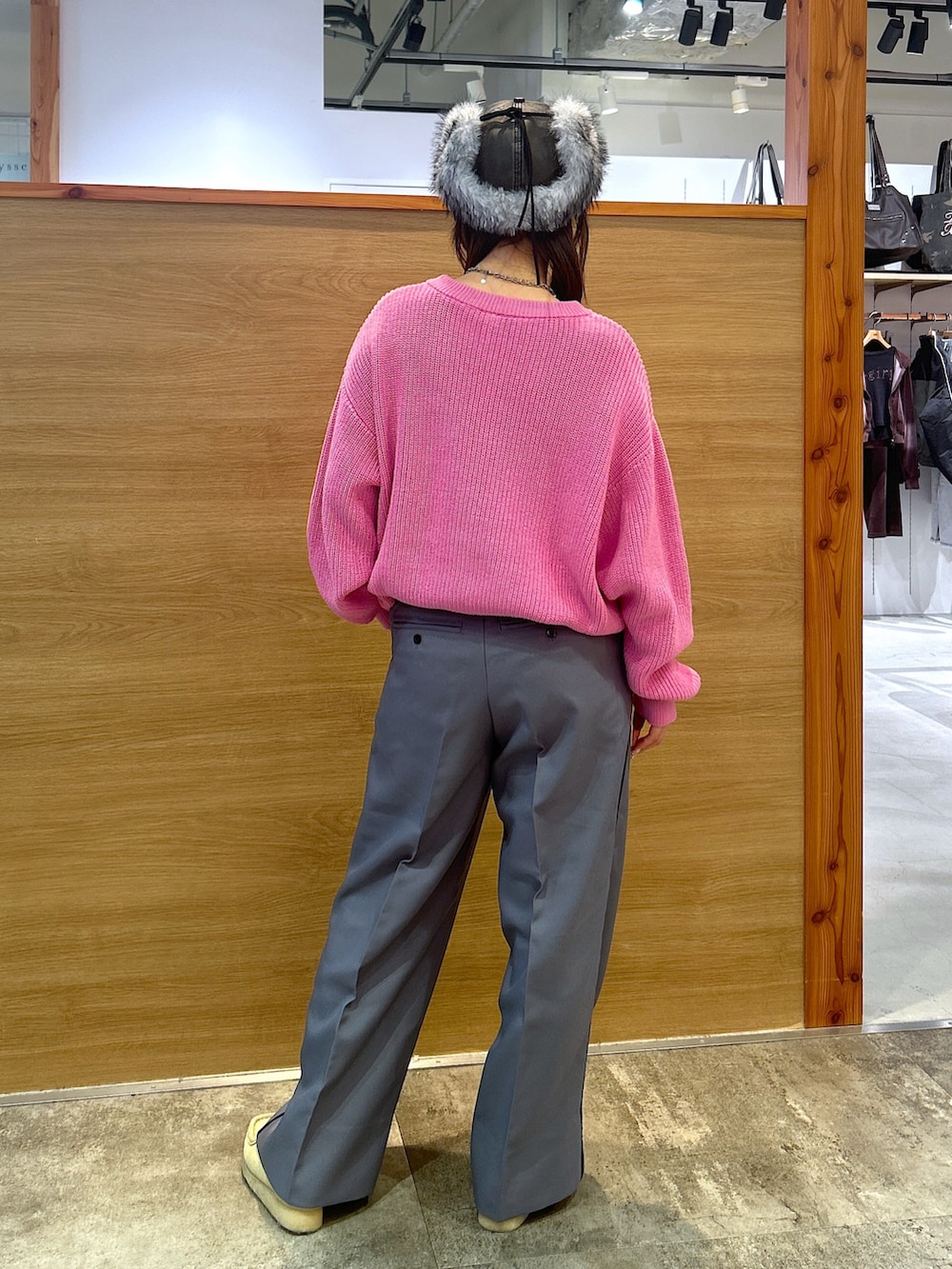 ピンク系のニット/セーター、グレー系のスラックス、ブラック系のキャップを着用したレディースの秋コーディネートの3枚目の写真