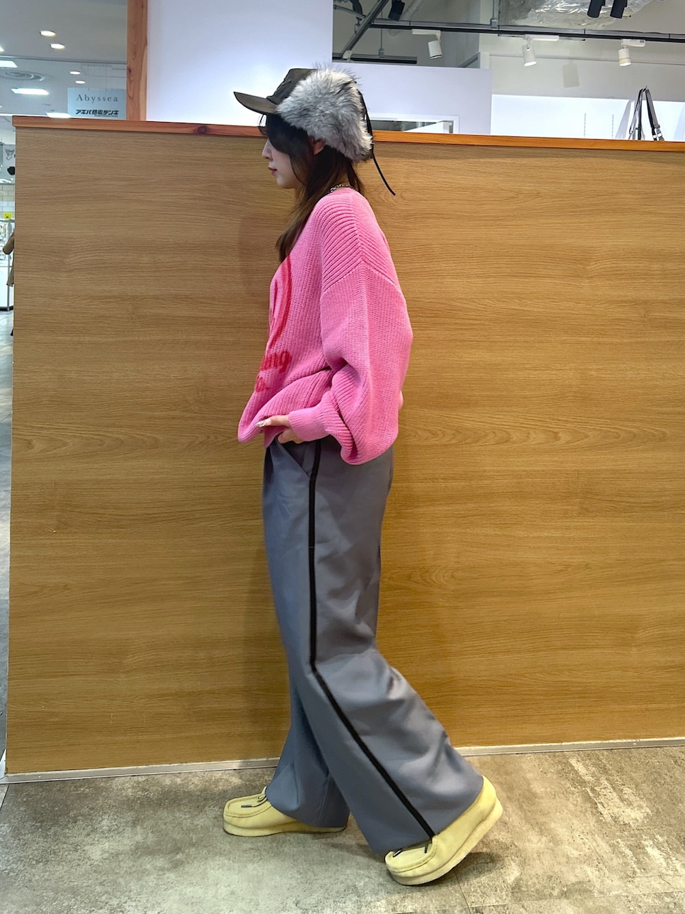 ピンク系のニット/セーター、グレー系のスラックス、ブラック系のキャップを着用したレディースの秋コーディネートの2枚目の写真