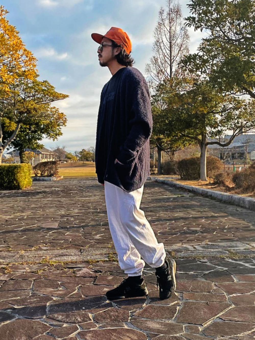 ホワイト系のスウェットパンツ、ブラック系のスニーカー、パープル系のカーディガン/ボレロを着用したメンズの春コーディネートの2枚目の写真