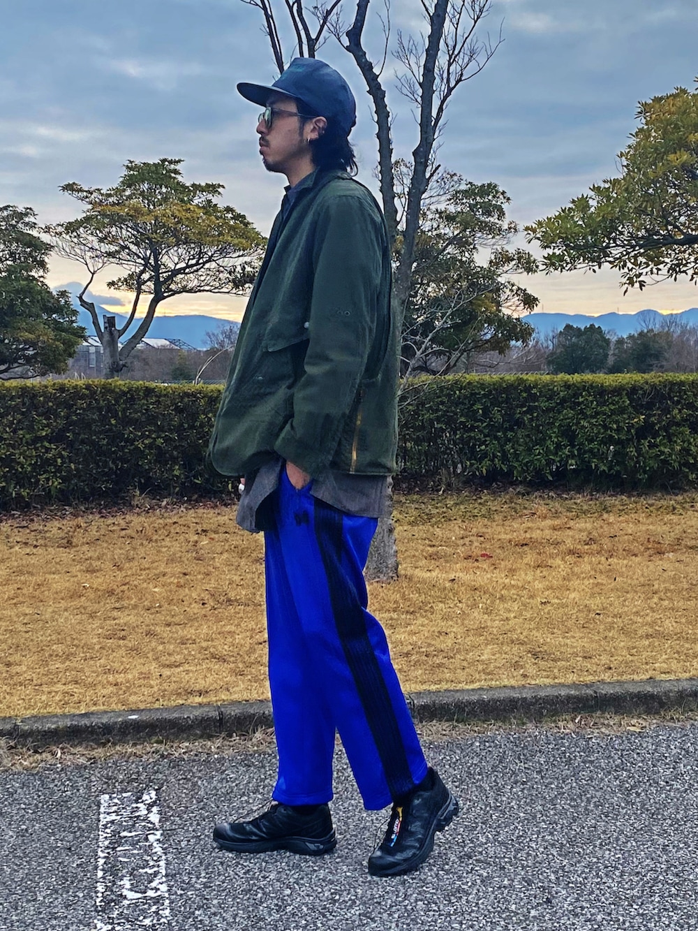 ブラック系のスニーカー、ブルー系のパンツ、グレー系のシャツ/ブラウスを着用したメンズの春コーディネートの2枚目の写真