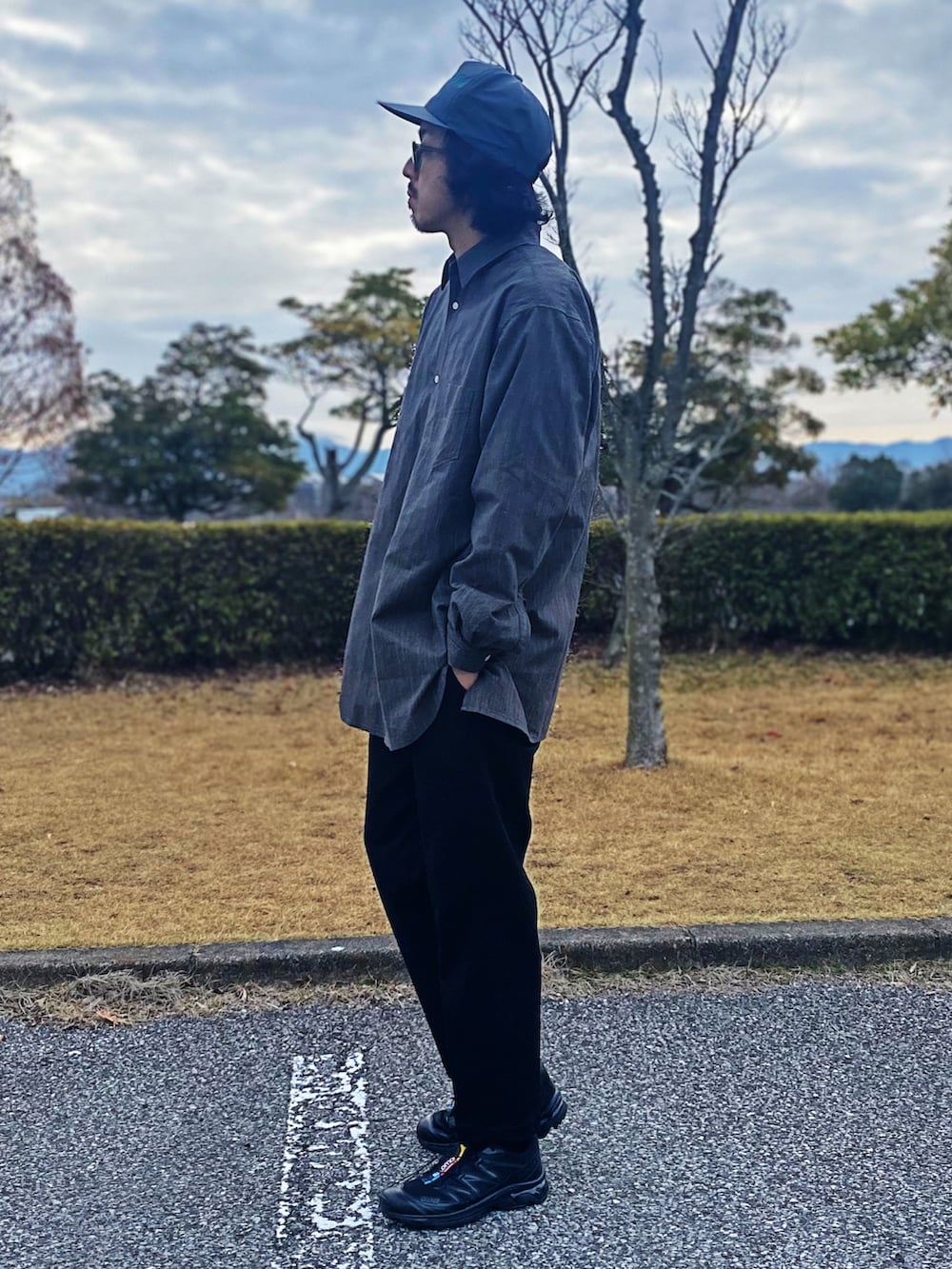 ブラック系のスニーカー、ブラック系のスラックス、グレー系のシャツ/ブラウスを着用したメンズの春コーディネートの2枚目の写真