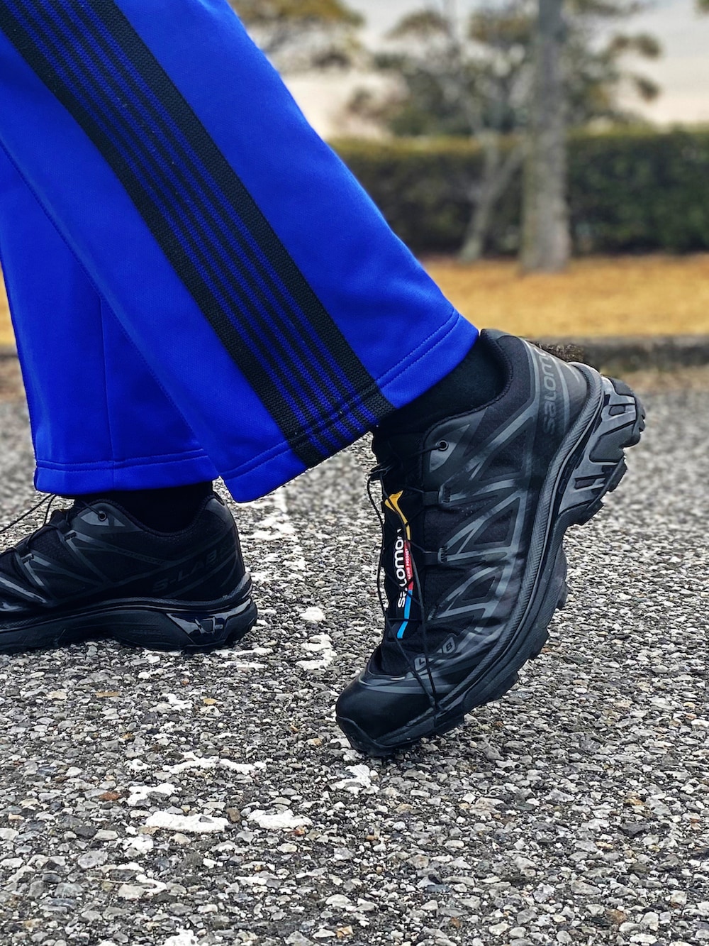 ブラック系のスニーカー、ブルー系のパンツ、グレー系のシャツ/ブラウスを着用したメンズの春コーディネートの4枚目の写真