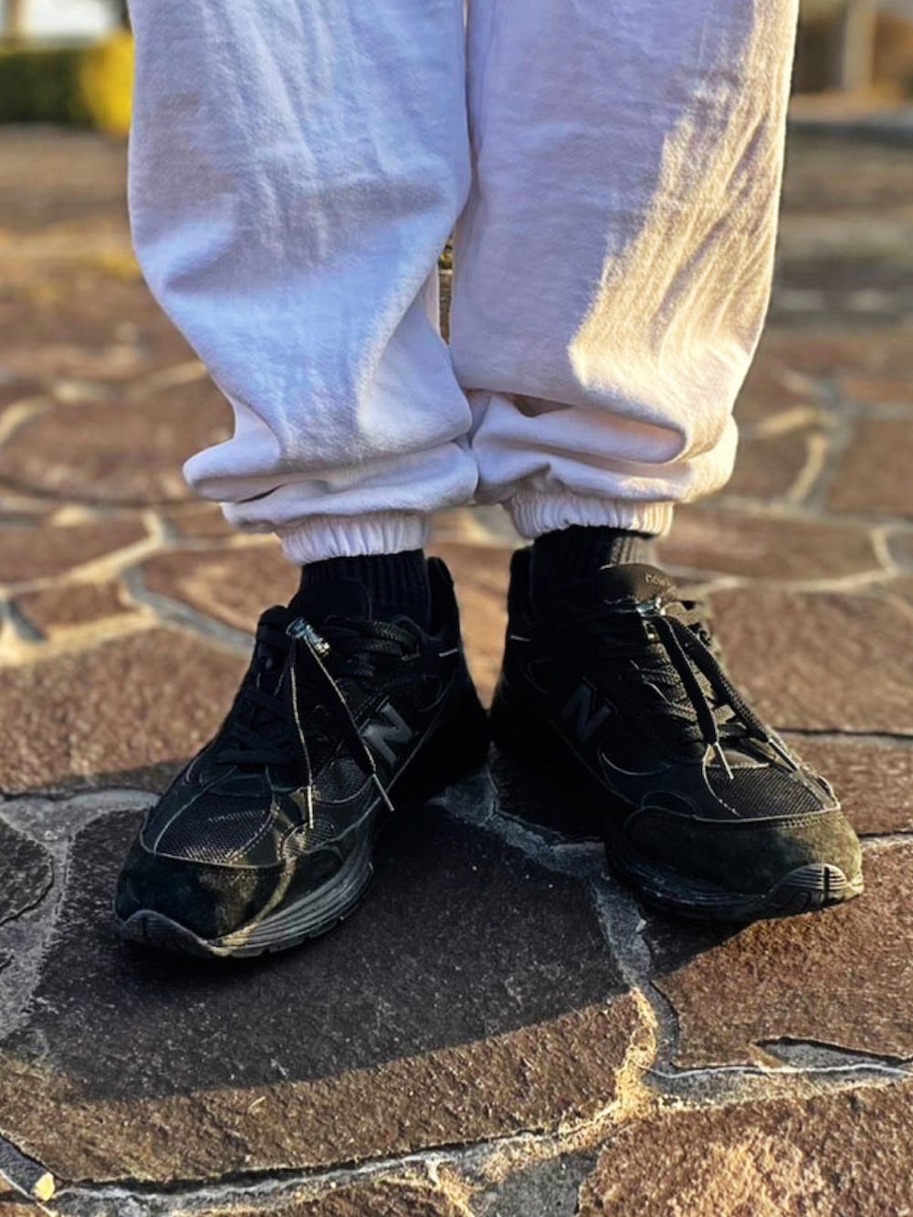 ホワイト系のスウェットパンツ、ブラック系のスニーカー、パープル系のカーディガン/ボレロを着用したメンズの春コーディネートの3枚目の写真