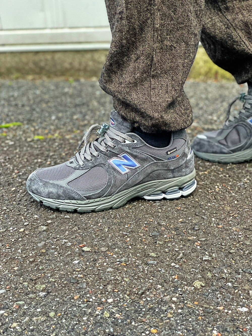 ブラック系のミリタリージャケット、ブラック系のモッズコート、ブラウン系のカーゴパンツを着用したメンズの冬コーディネートの4枚目の写真