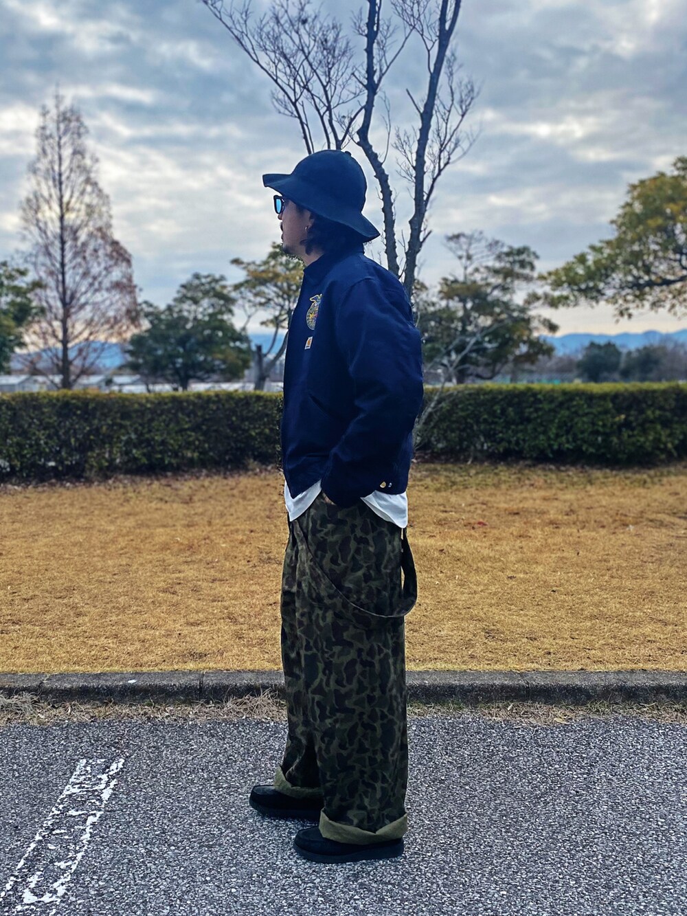 グリーン系のサロペット/オーバーオール、ブラック系のローファー、ホワイト系のTシャツ/カットソーを着用したメンズの春コーディネートの2枚目の写真