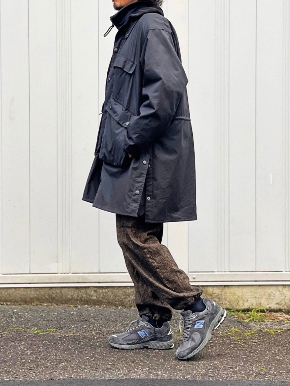 ブラック系のミリタリージャケット、ブラック系のモッズコート、ブラウン系のカーゴパンツを着用したメンズの冬コーディネートの2枚目の写真