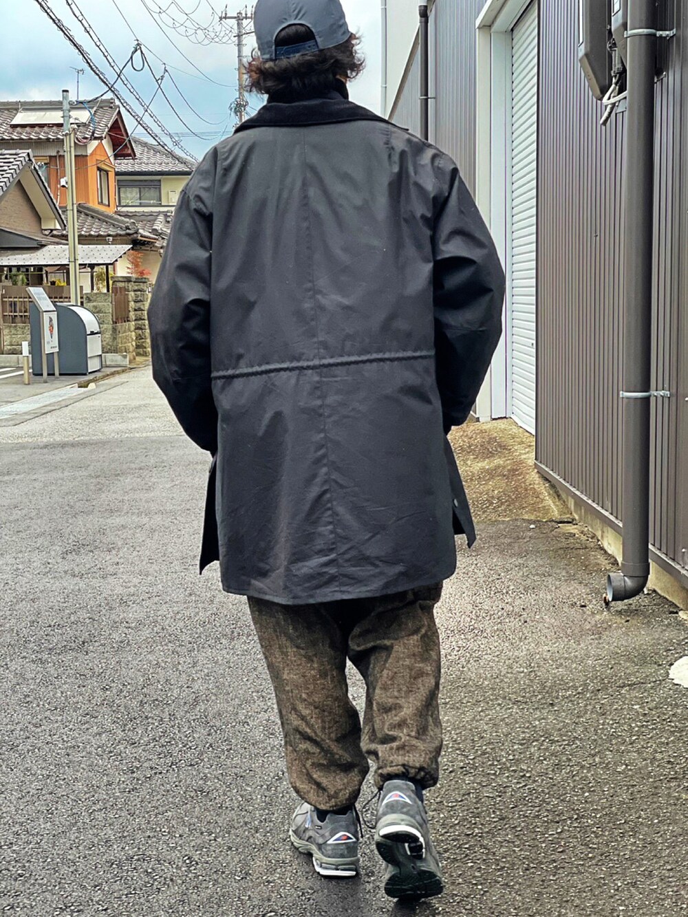 ブラック系のミリタリージャケット、ブラック系のモッズコート、ブラウン系のカーゴパンツを着用したメンズの冬コーディネートの3枚目の写真