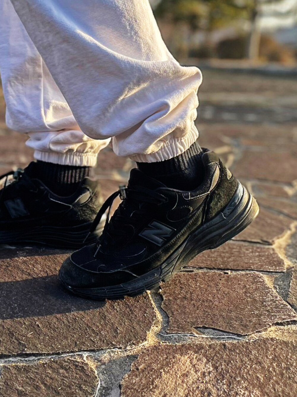 ホワイト系のスウェットパンツ、ブラック系のスニーカー、パープル系のカーディガン/ボレロを着用したメンズの春コーディネートの4枚目の写真