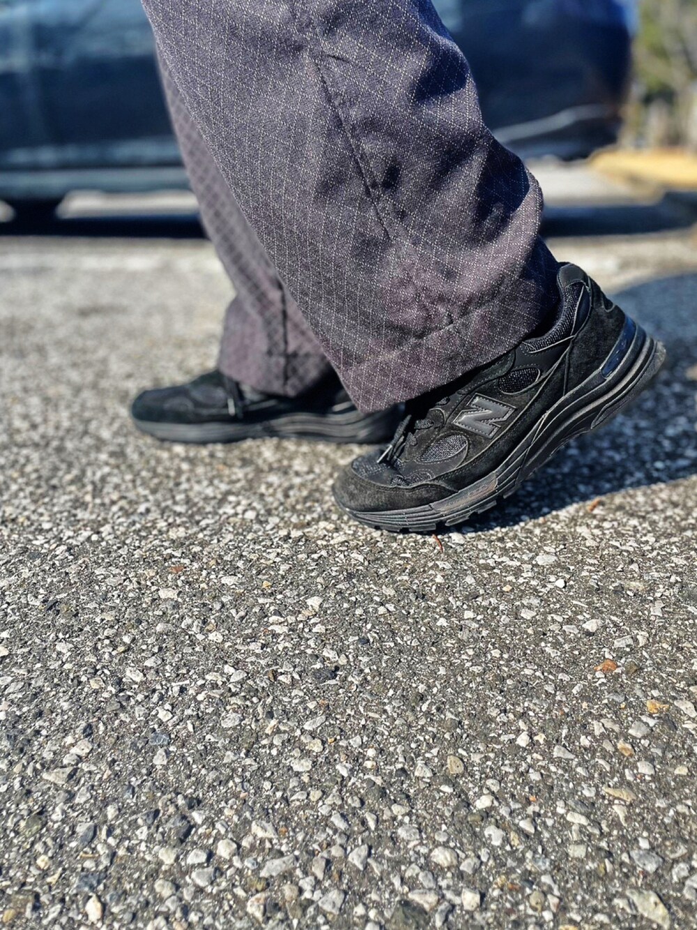 グリーン系のミリタリージャケット、グレー系のスラックス、ブラック系のスニーカーを着用したメンズの春コーディネートの4枚目の写真