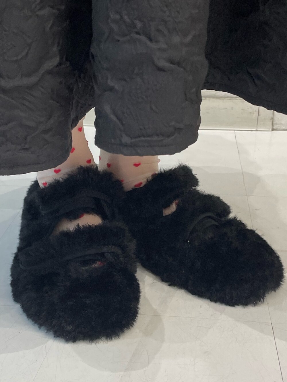 ブラック系のワンピース、レッド系のカーディガン/ボレロ、ホワイト系のニット/セーターを着用したレディースの秋コーディネートの7枚目の写真