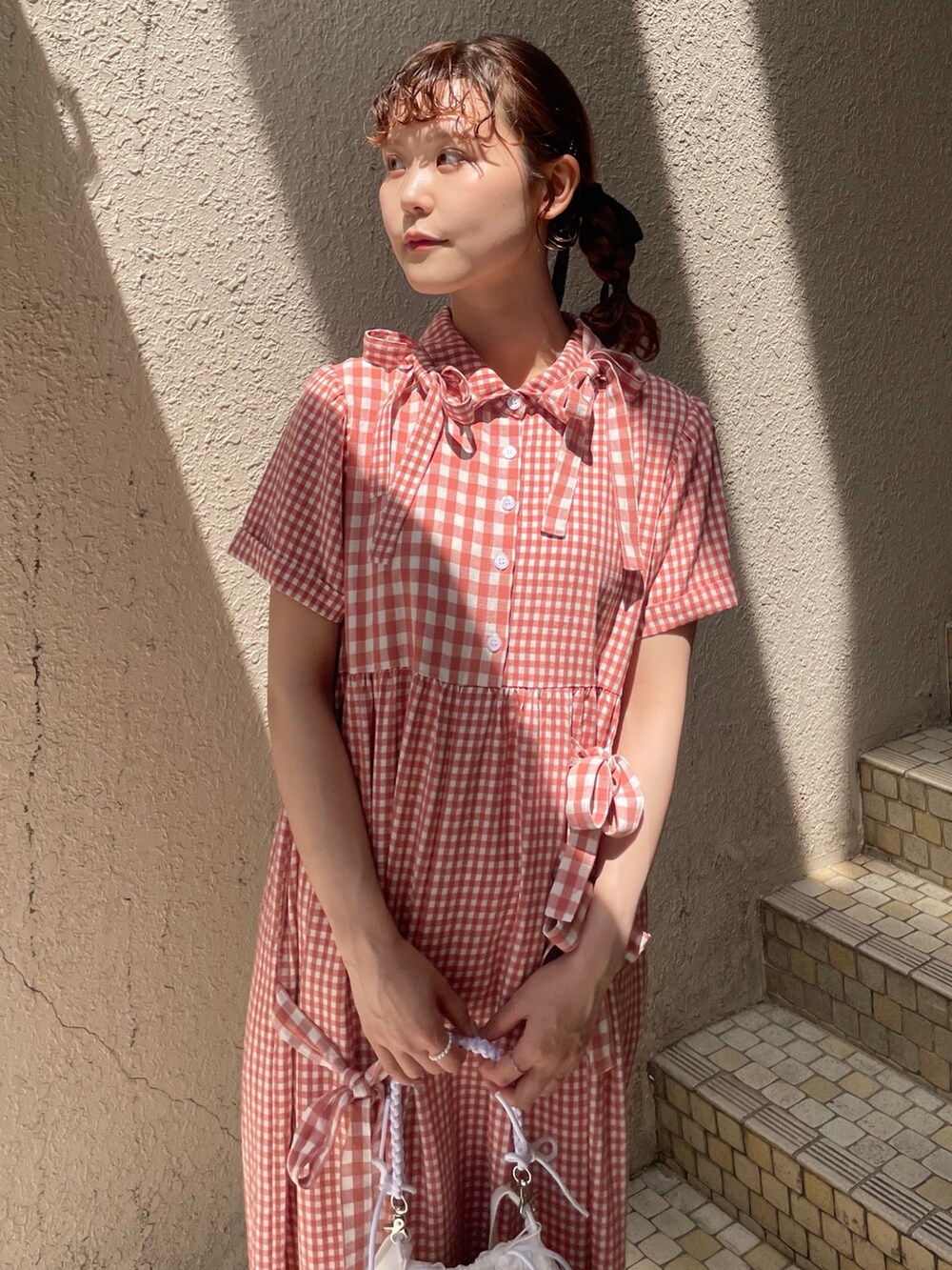 レッド系のワンピース、ホワイト系のショルダーバッグ、ホワイト系のサンダルを着用したレディースの春コーディネートの6枚目の写真