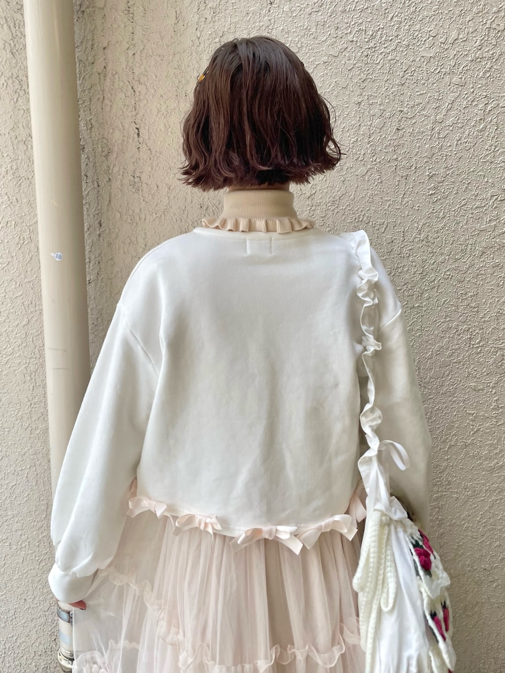 ホワイト系のニット/セーター、ピンク系のワンピース、ホワイト系のショルダーバッグを着用したレディースの冬コーディネートの5枚目の写真