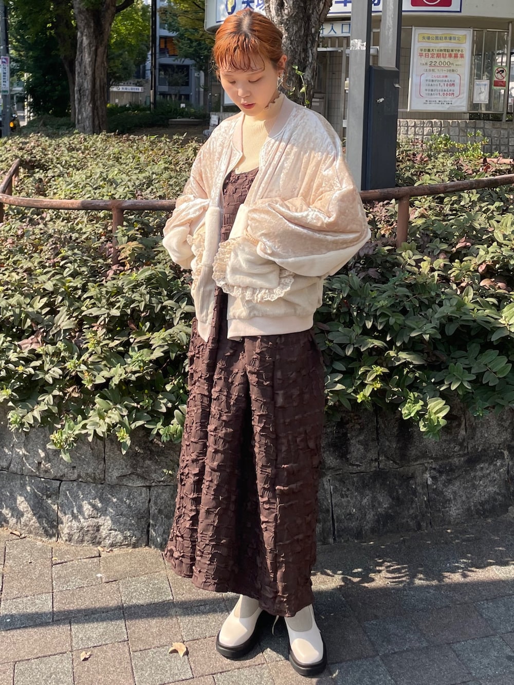 ブラウン系のワンピース、ホワイト系のブルゾン、イエロー系のニット/セーターを着用したレディースの秋コーディネートの2枚目の写真