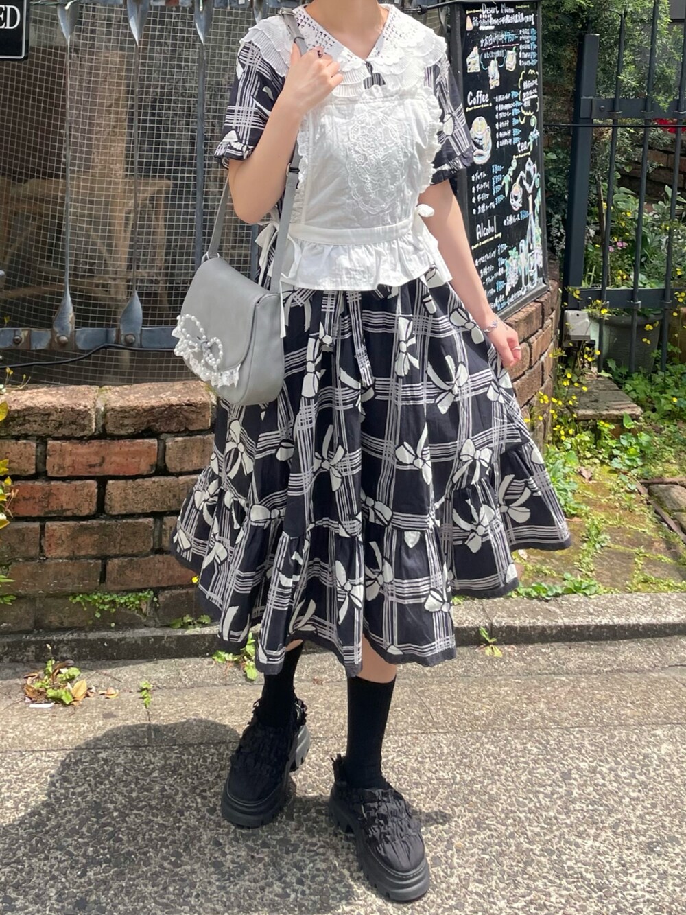 ブラック系のサンダル、ホワイト系のシャツ/ブラウス、ブルー系のショルダーバッグを着用したレディースの春コーディネートの8枚目の写真