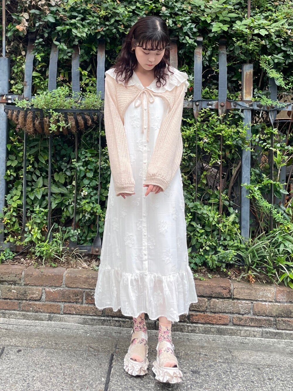 ホワイト系のサンダル、ベージュ系のカーディガン/ボレロ、ホワイト系のワンピースを着用したレディースの夏コーディネートの2枚目の写真
