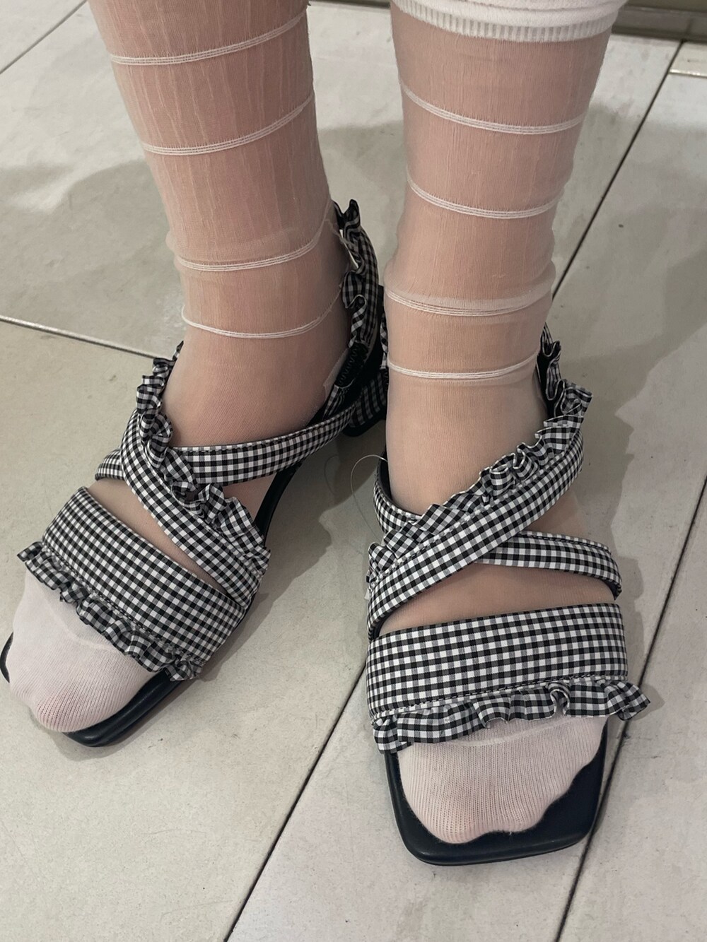 ホワイト系のワンピース、ブラック系のサンダル、ホワイト系の付け襟を着用したレディースの夏コーディネートの6枚目の写真