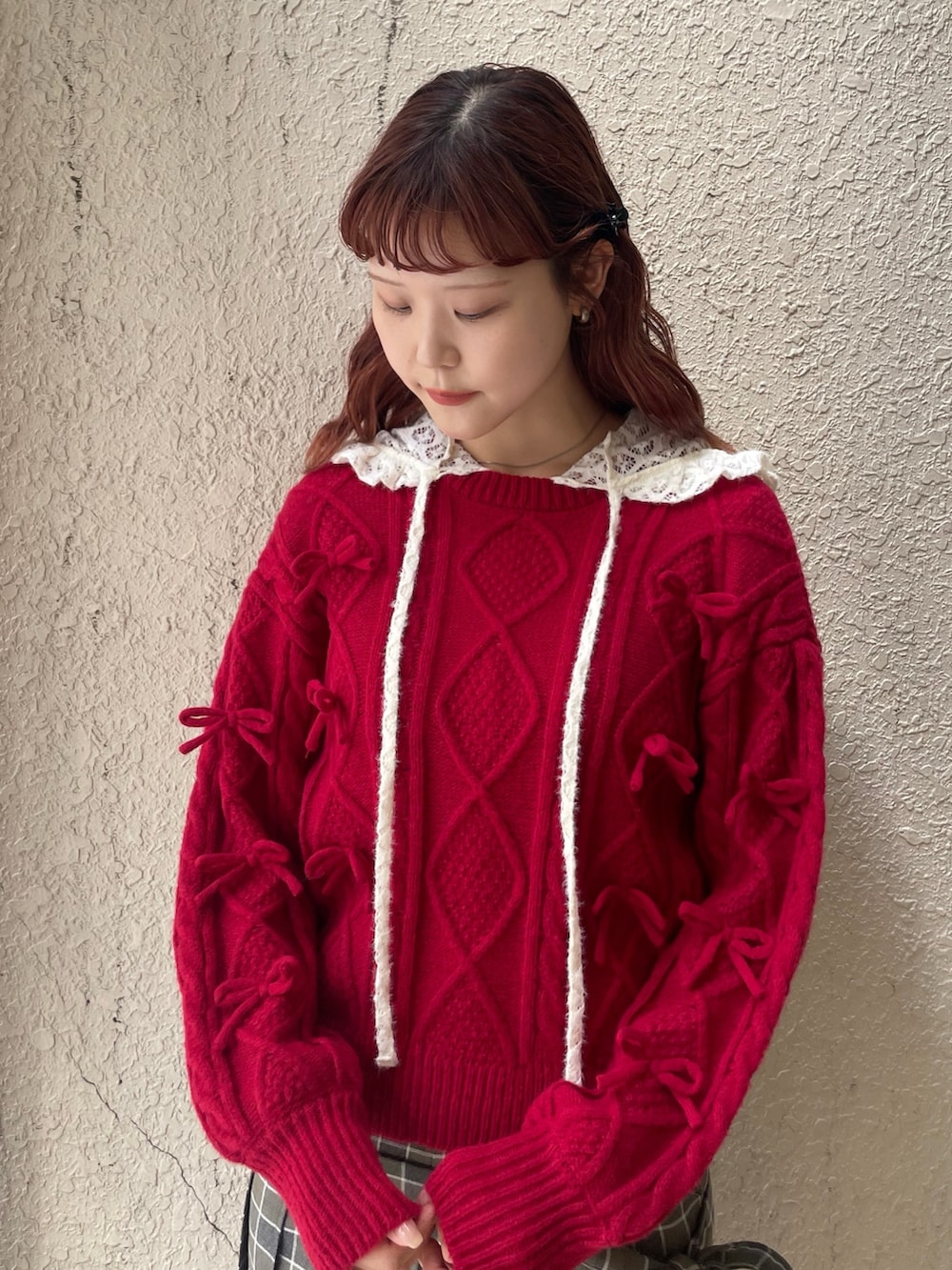 レッド系のニット/セーター、グリーン系のスラックス、ホワイト系のTシャツ/カットソーを着用したレディースの秋コーディネートの4枚目の写真