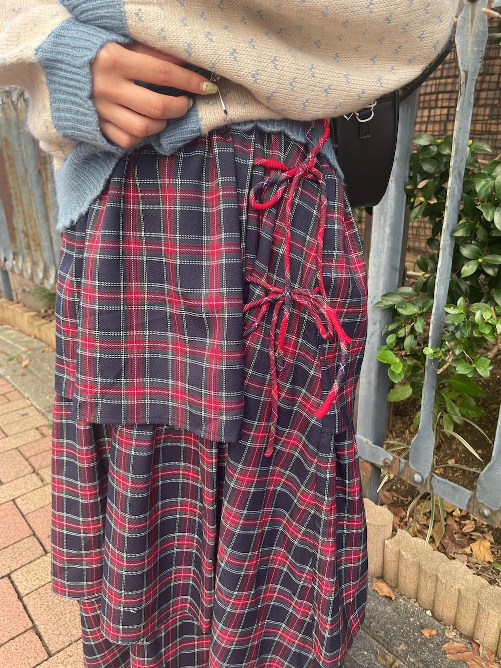 ブルー系のスカート、ブルー系のカーディガン/ボレロ、ブラック系のニット/セーターを着用したレディースの秋コーディネートの7枚目の写真