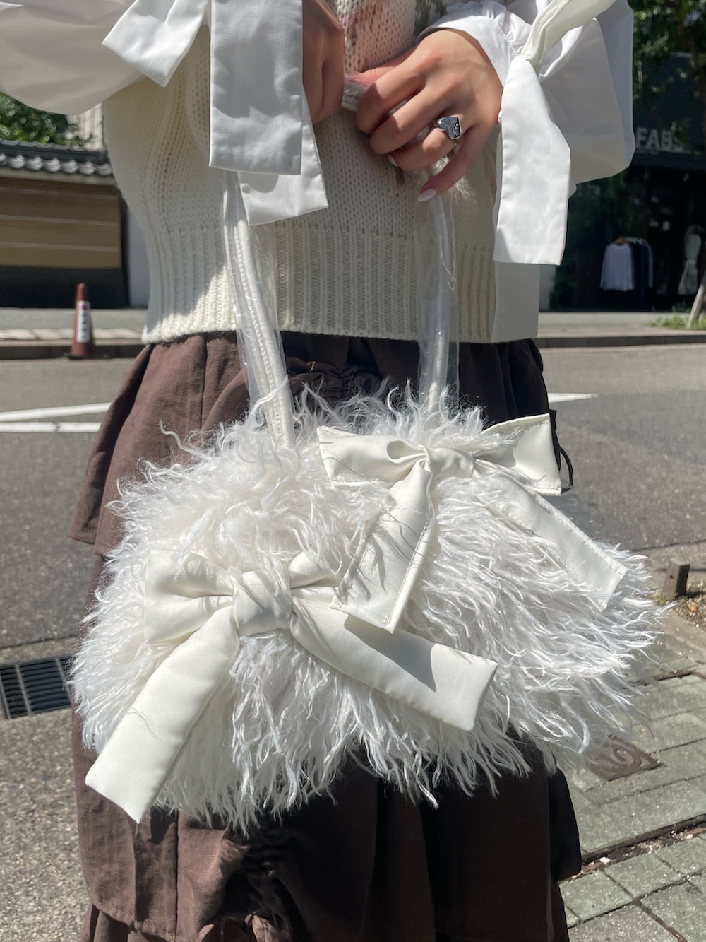 ホワイト系のボストンバッグ、ホワイト系のベスト、ホワイト系のシャツ/ブラウスを着用したレディースの秋コーディネートの7枚目の写真