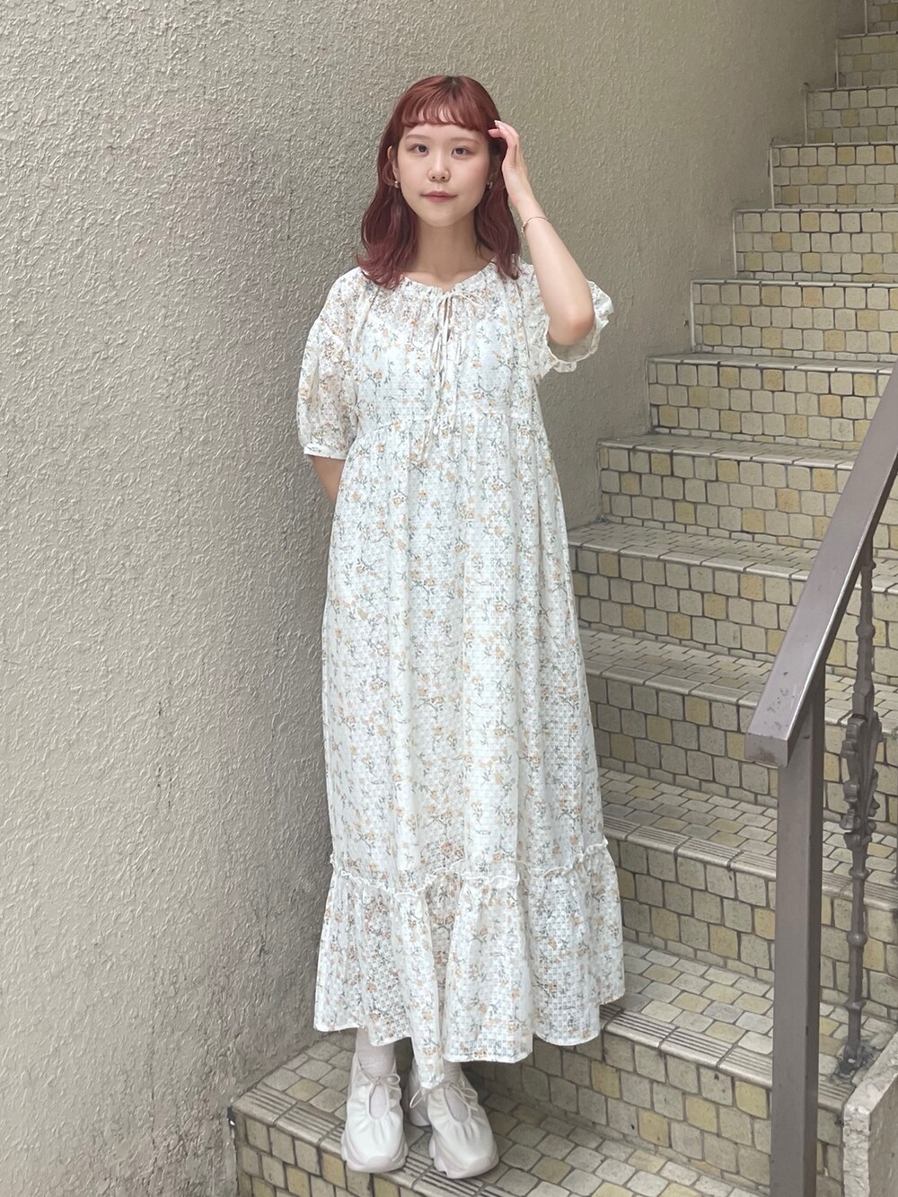 イエロー系のワンピース、ホワイト系のスニーカーを着用したレディースの夏コーディネートの2枚目の写真