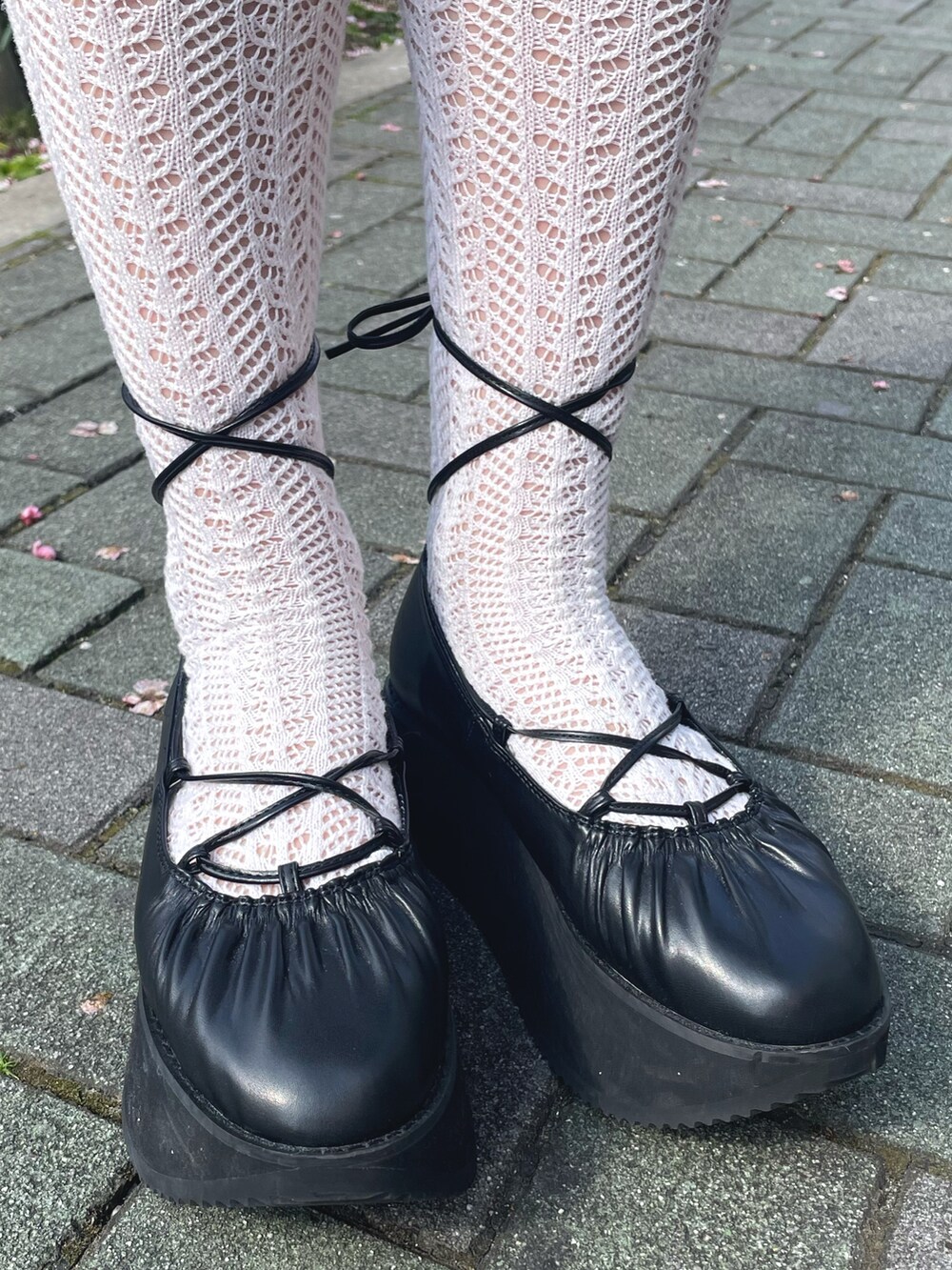ブラック系のワンピース、ブラック系のカーディガン/ボレロ、ブラック系のバレエシューズを着用したレディースの春コーディネートの5枚目の写真