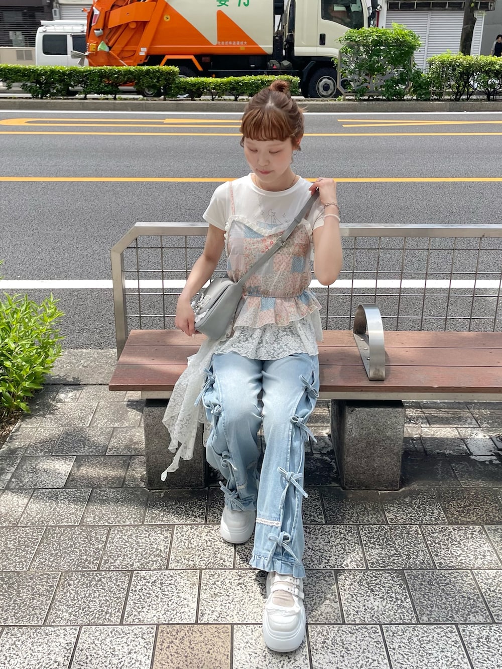 ブルー系のデニムパンツ、ブルー系のショルダーバッグ、ホワイト系のスニーカーを着用したレディースの夏コーディネートの5枚目の写真