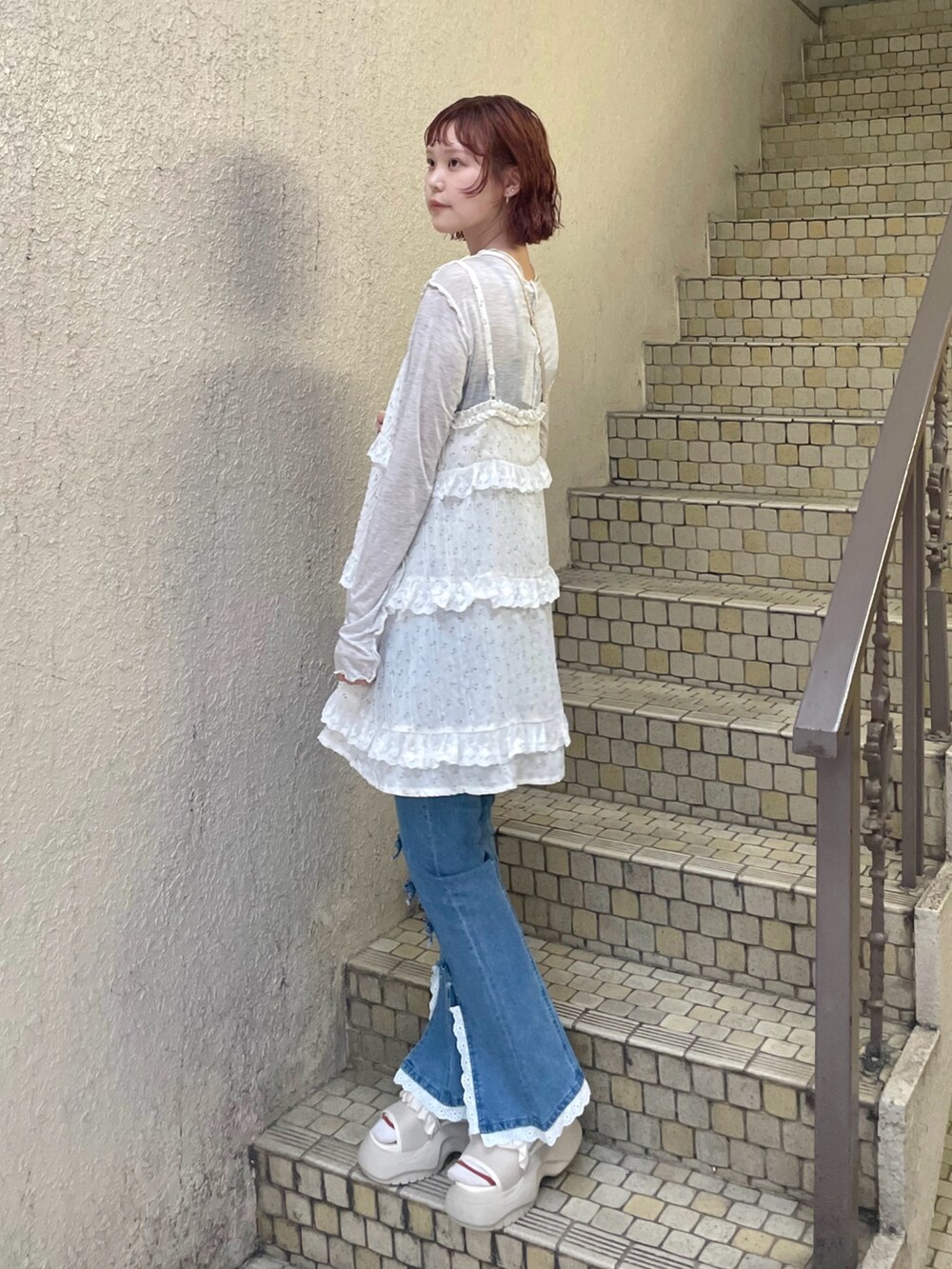 ブルー系のデニムパンツ、グレー系のTシャツ/カットソー、ホワイト系のサンダルを着用したレディースの夏コーディネートの3枚目の写真