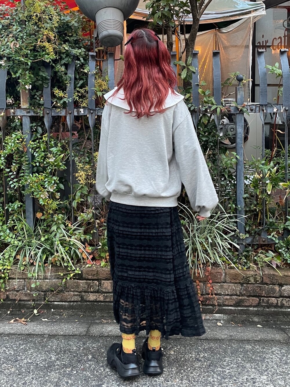 グレー系のスウェット、ブラック系のスカート、ブラック系のスニーカーを着用したレディースの冬コーディネートの3枚目の写真