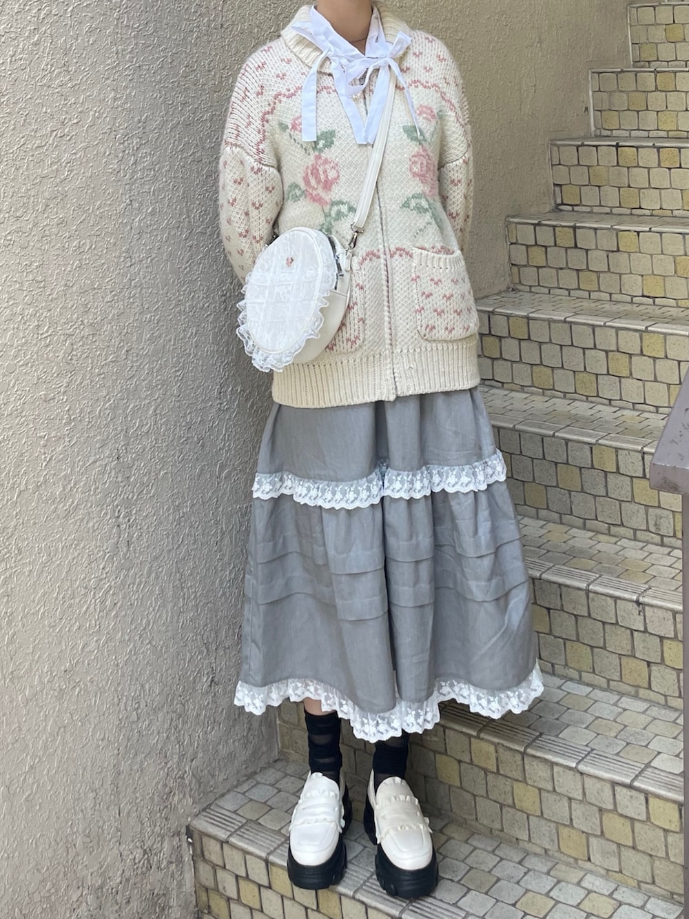 ホワイト系のシャツ/ブラウス、グレー系のスカート、ホワイト系のローファーを着用したレディースの秋コーディネートの2枚目の写真