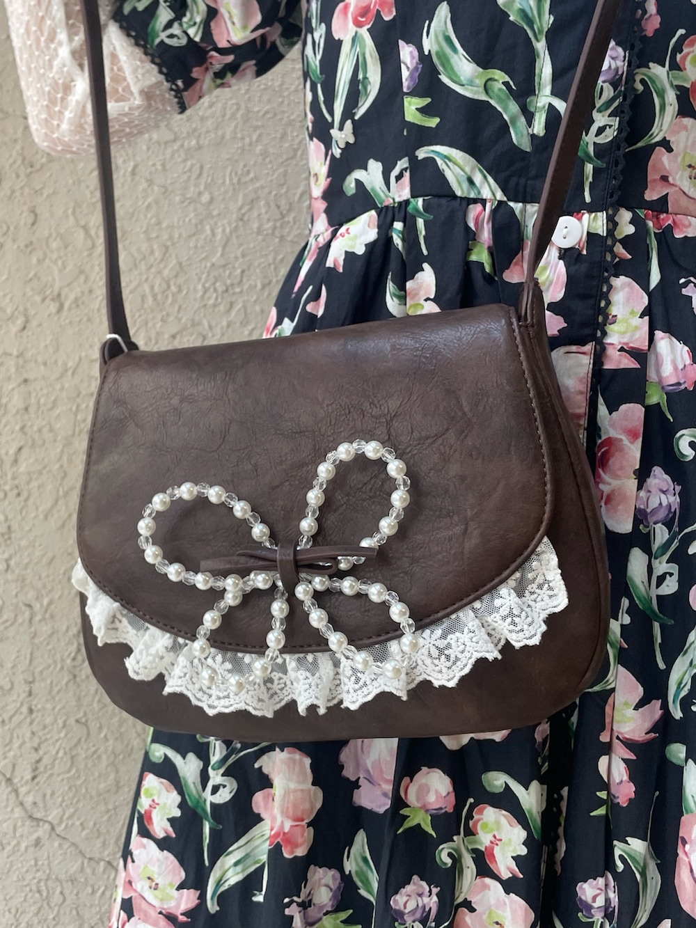 ブラック系のワンピース、ブラウン系のショルダーバッグ、ホワイト系のTシャツ/カットソーを着用したレディースの春コーディネートの7枚目の写真