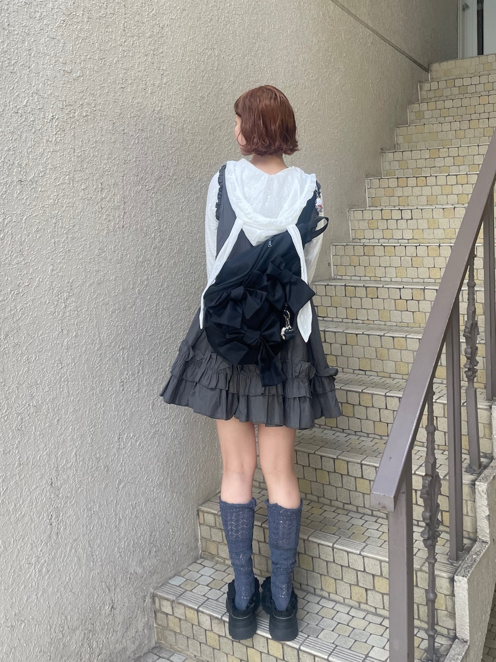 ブラック系のサンダル、グレー系のワンピース、ブラック系のショルダーバッグを着用したレディースの冬コーディネートの5枚目の写真