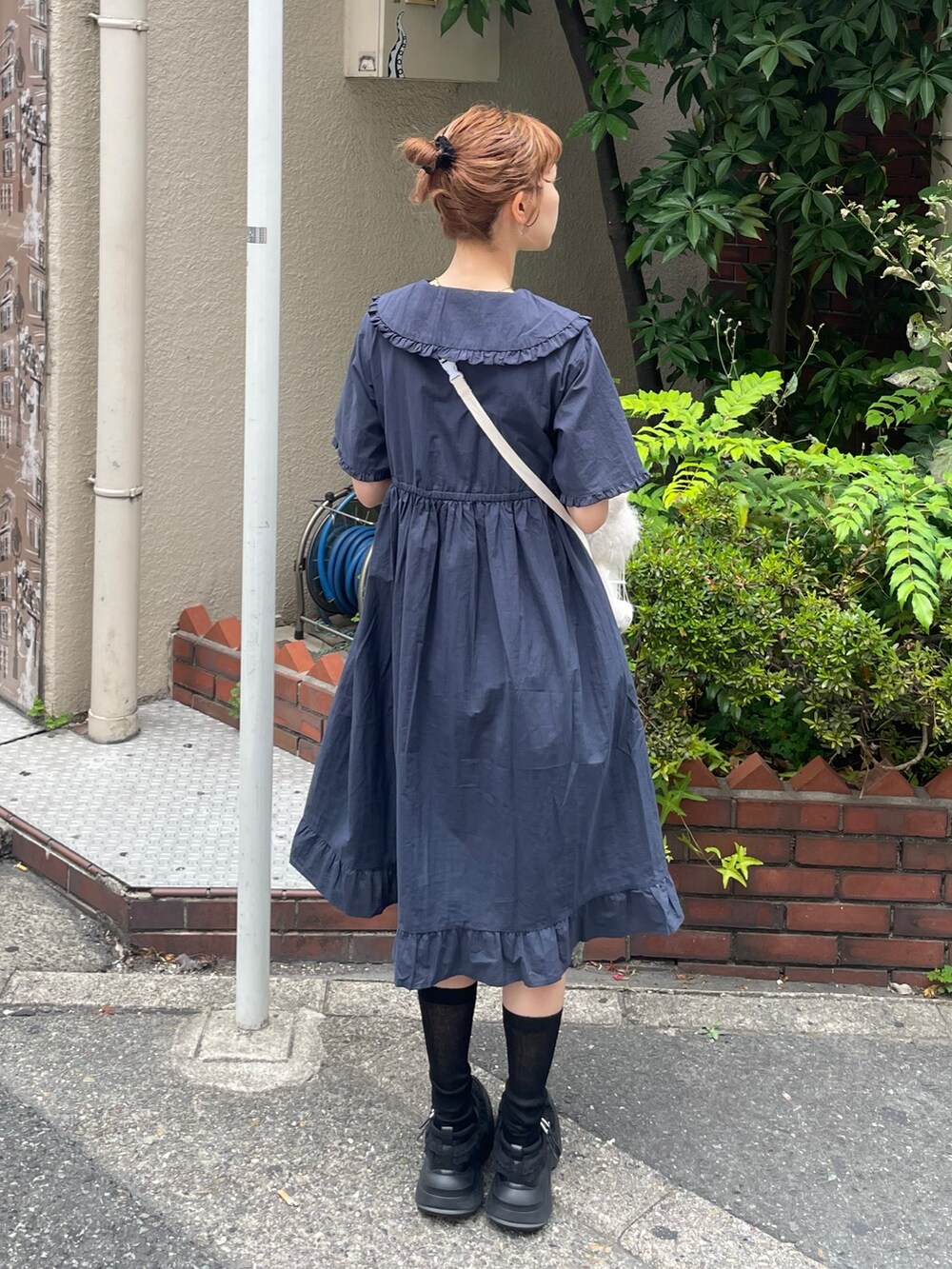 ブルー系のワンピース、ブラック系のスニーカー、ホワイト系のショルダーバッグを着用したレディースの夏コーディネートの3枚目の写真