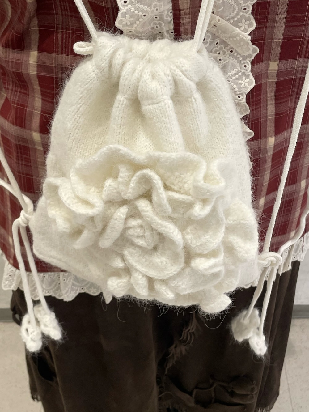レッド系のシャツ/ブラウス、ブラウン系のスカート、ホワイト系のバックパック/リュックを着用したレディースの秋コーディネートの7枚目の写真