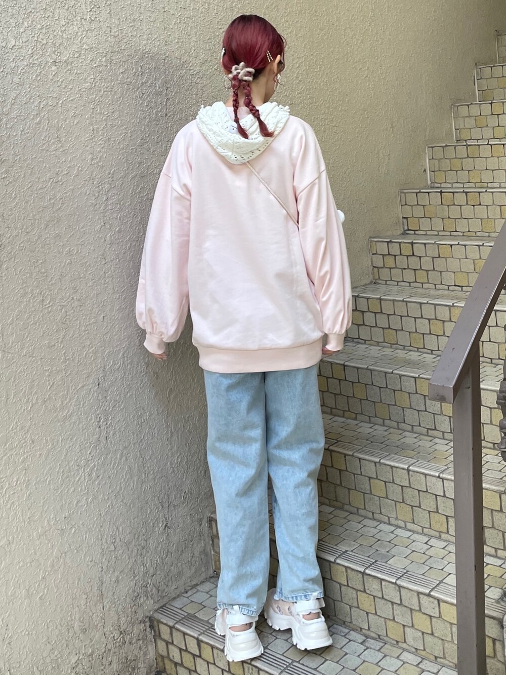 ブルー系のデニムパンツ、ピンク系のスニーカー、ホワイト系のショルダーバッグを着用したレディースの冬コーディネートの2枚目の写真