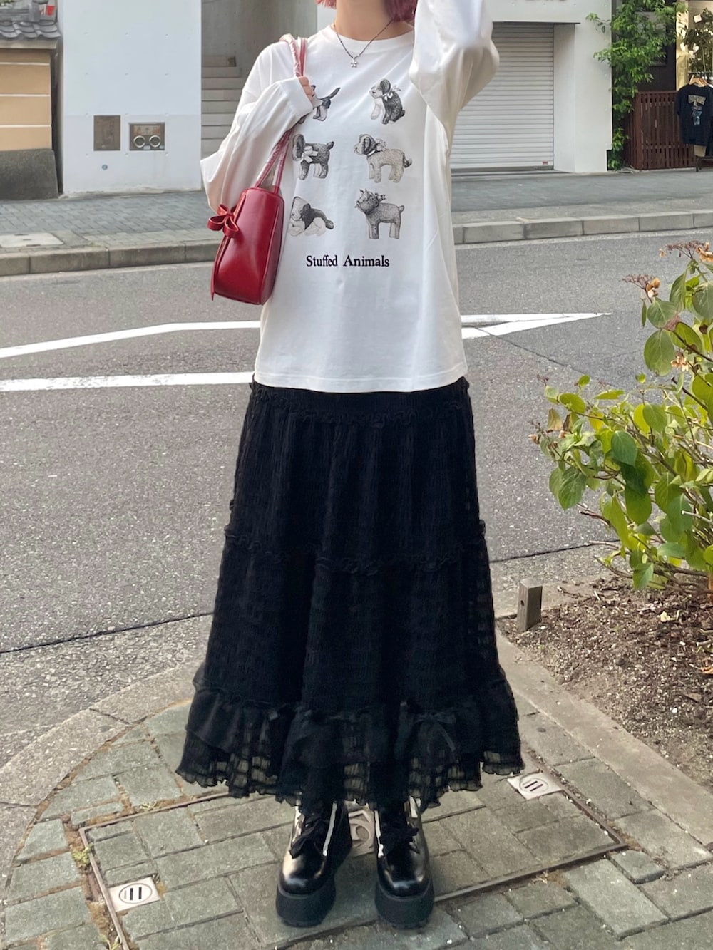 ホワイト系のTシャツ/カットソー、ブラック系のスカート、ブラック系のブーツを着用したレディースの夏コーディネートの2枚目の写真