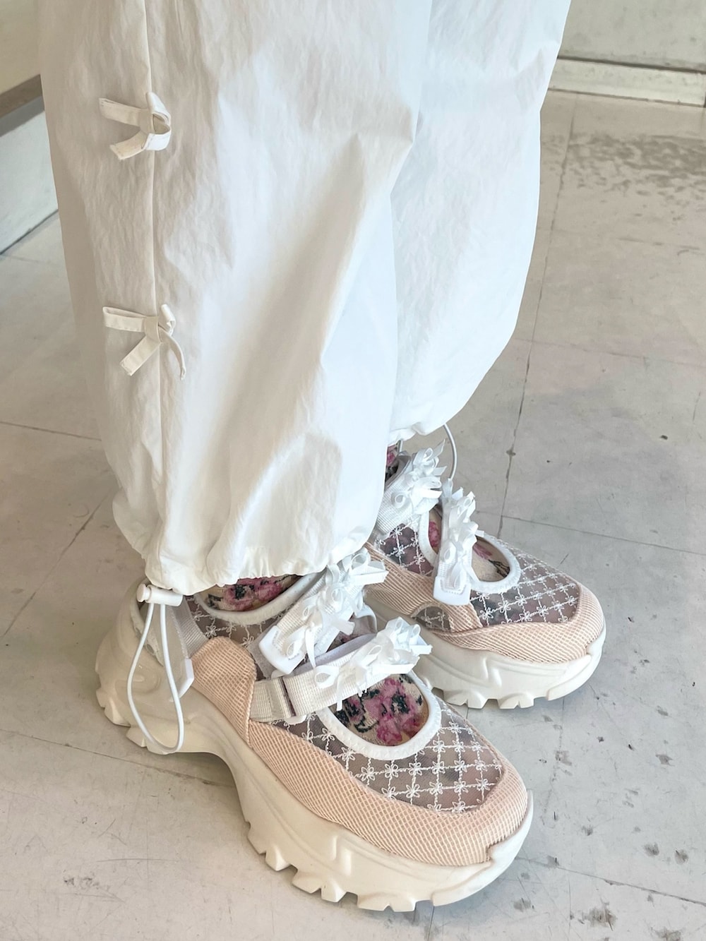 ピンク系のスニーカー、ピンク系のショルダーバッグ、ピンク系のジャージを着用したレディースの冬コーディネートの7枚目の写真