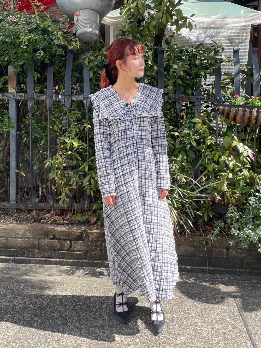 ブルー系のワンピース、ブラック系のパンプスを着用したレディースの春コーディネートの2枚目の写真