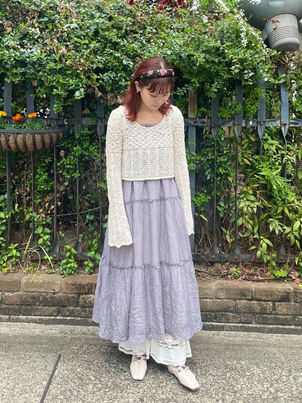 ホワイト系のニット/セーター、グレー系のワンピース、ホワイト系のスラックスを着用したレディースの春コーディネートの2枚目の写真