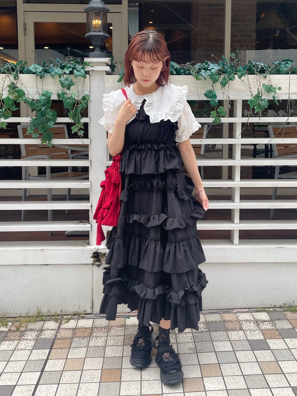 ブラック系のワンピース、ブラック系のサンダル、ホワイト系のシャツ/ブラウスを着用したレディースの夏コーディネートの2枚目の写真