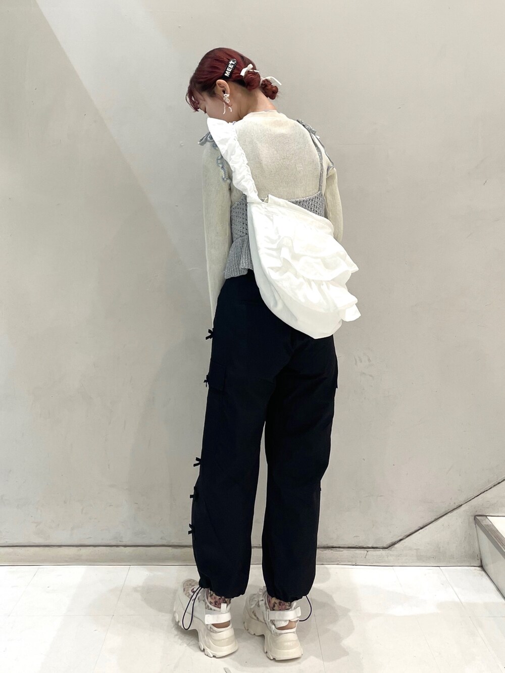 ブラック系のカーゴパンツ、ホワイト系のスニーカー、ホワイト系のTシャツ/カットソーを着用したレディースの冬コーディネートの2枚目の写真